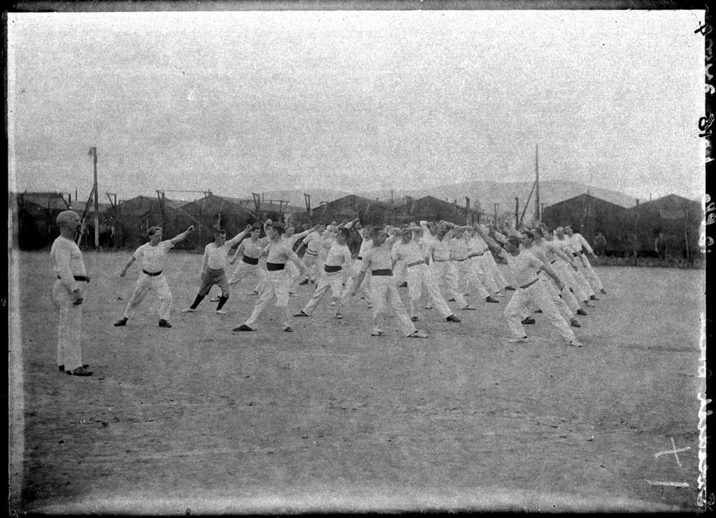 First World War Internee Physical Exercise Group (Huts and Wire in background), Knockaloe Camp, Isle of Man, 1917